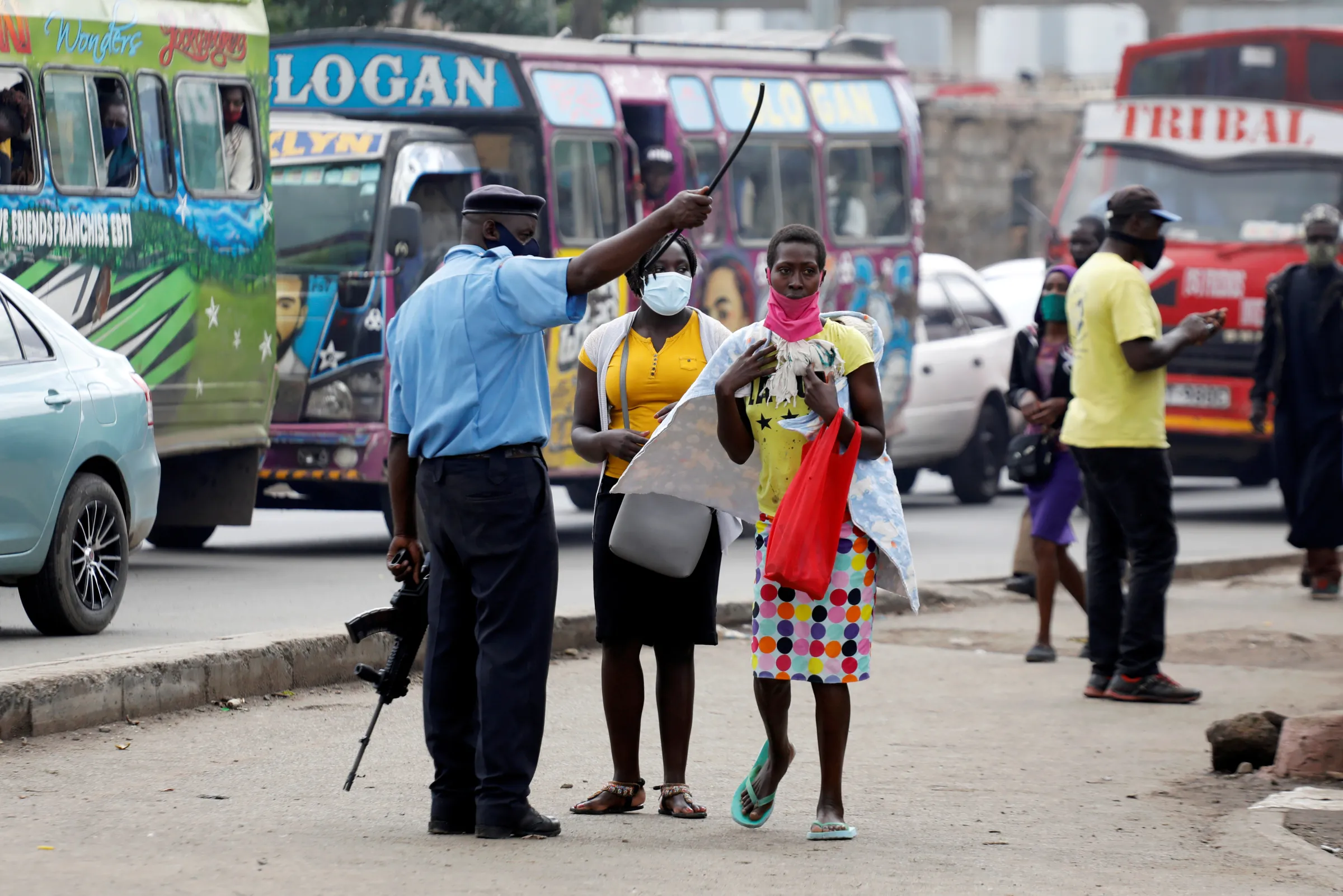 A police officer interacts with pedestrians near a police checkpoint, after the government announced a lockdown of Nairobi's storied Eastleigh district and the Old Town of Mombasa for two weeks following a jump in confirmed coronavirus disease (COVID-19) cases there, Nairobi, Kenya May 7, 2020. REUTERS/Baz Ratner