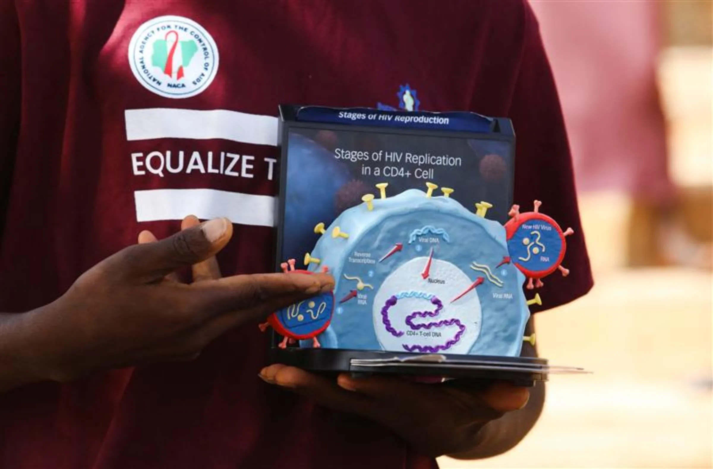 Peer educator Abraham Nnam uses a model of the HIV virus to illustrate a lesson on AIDS to youths at a primary health centre in Kobi suburb, Abuja, Nigeria November 30, 2022. REUTERS/Afolabi Sotunde