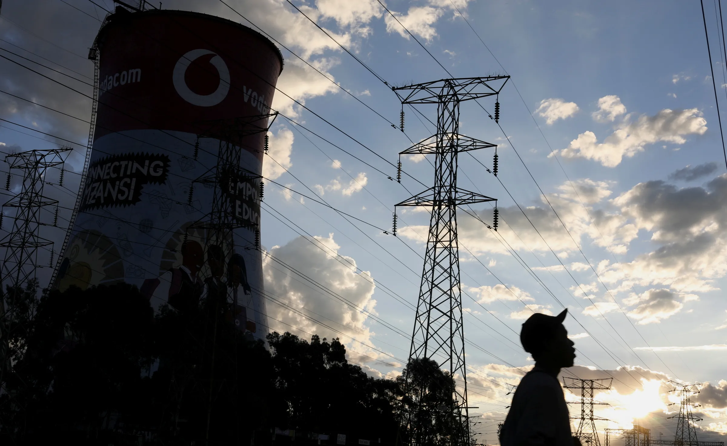 A man walks below Eskom's electricity pylons in Soweto, South Africa, March 18, 2021. REUTERS/Siphiwe Sibeko